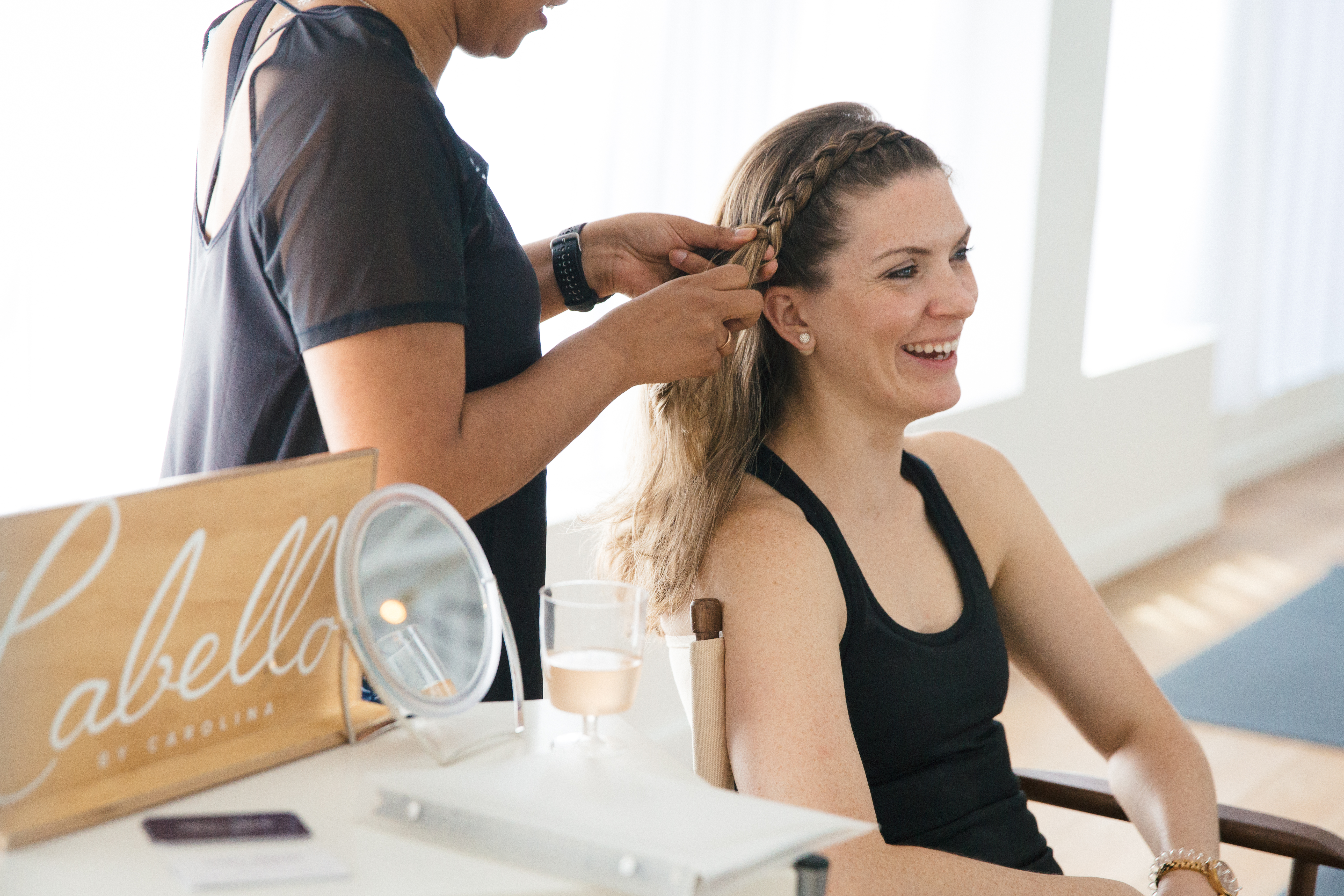 A woman gets her hair braided at a birthday barre-ty