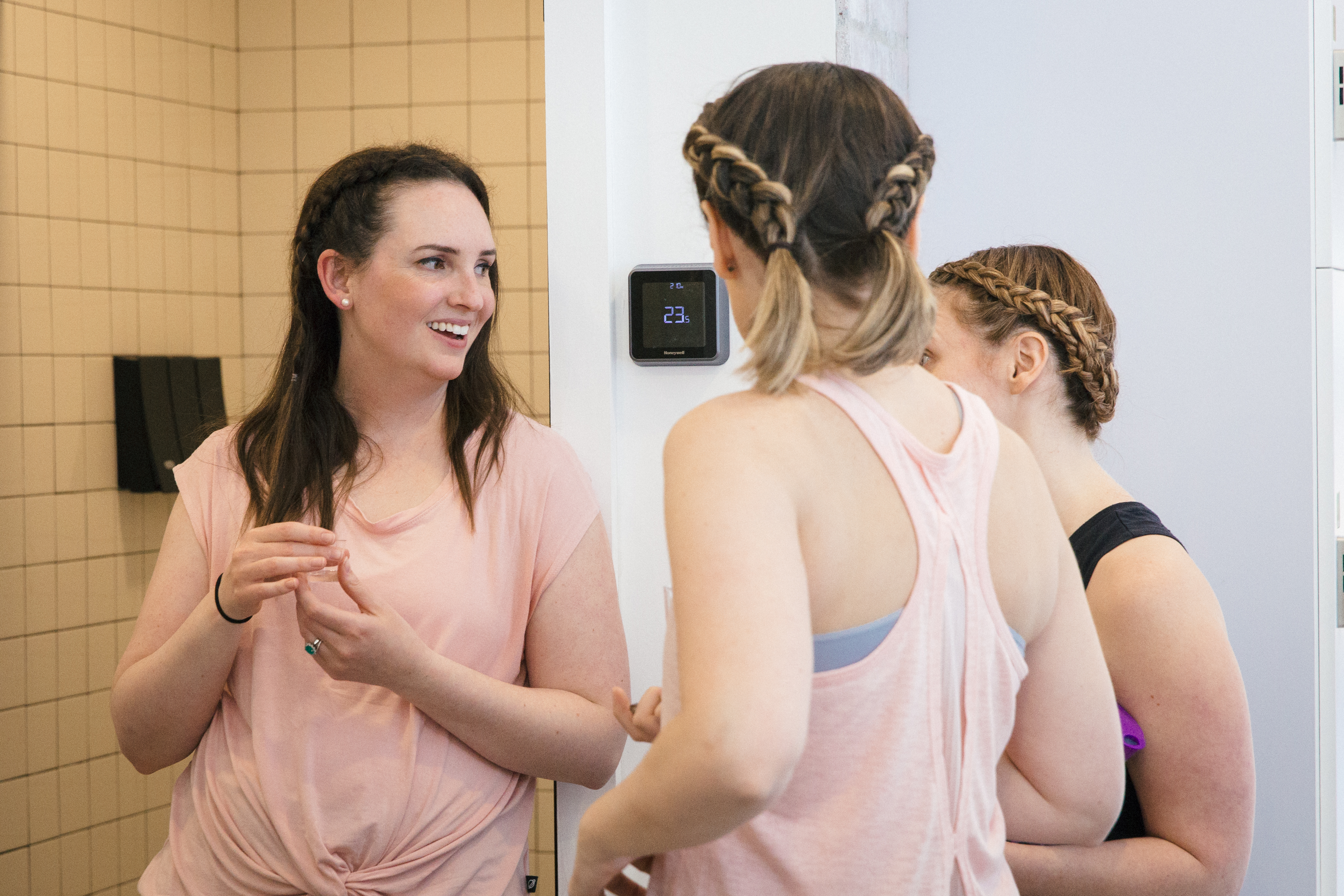 Three women socialize at a birthday barre-ty