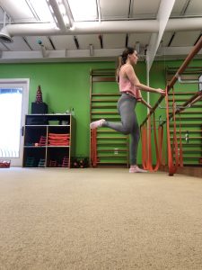 Woman at the barre doing standing pretzel