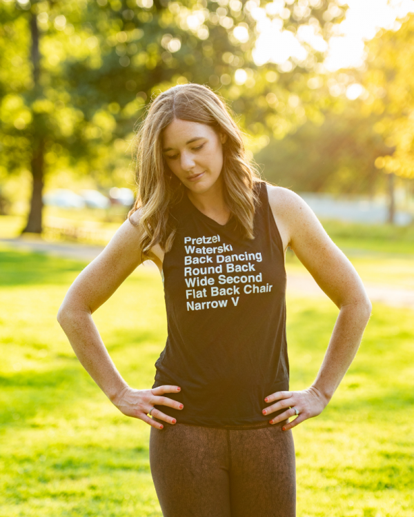 A woman models the List of Barre Exercises Scoop Muscle Tank Top in Black