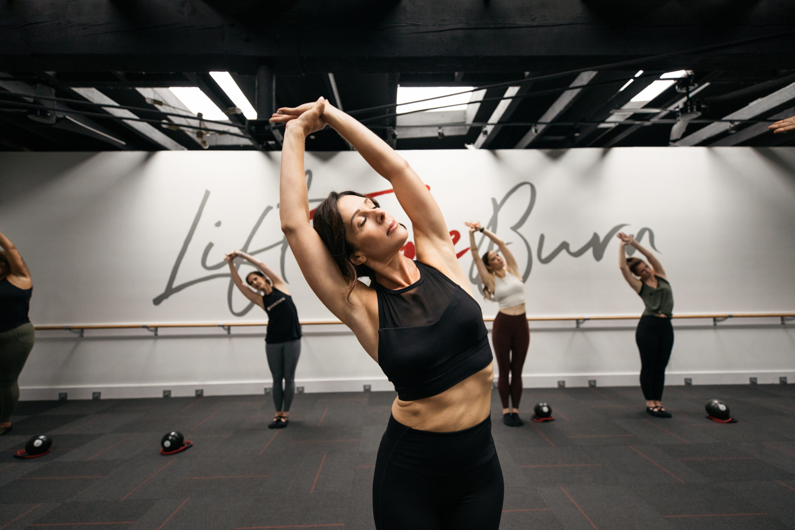 A woman stretches during a Pure Barre Align class